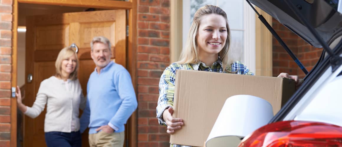 A young woman packing boxes, daughter moving out of parents' home.
