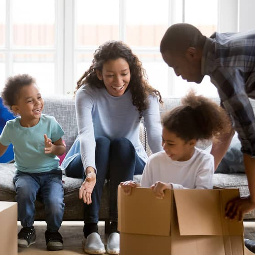 Family moving into a home, unloading boxes and settling into their new living space.